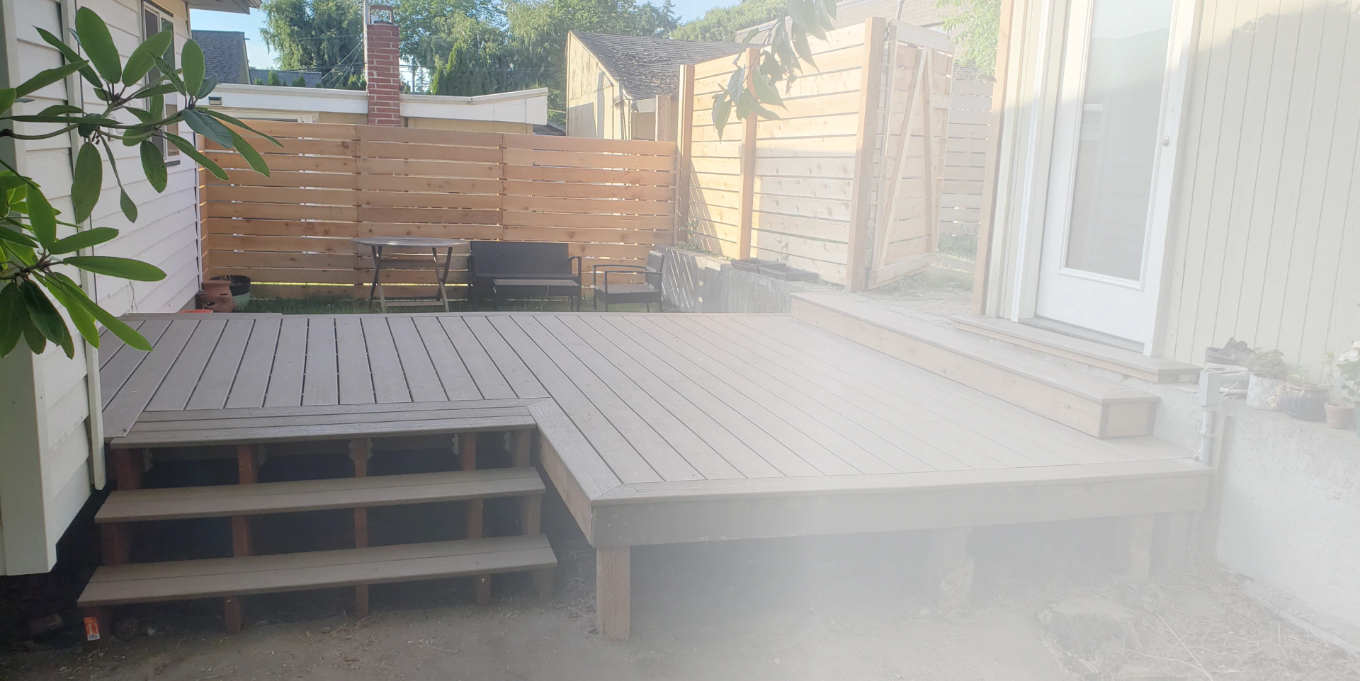 brown deck outside of a house with white frame dooors